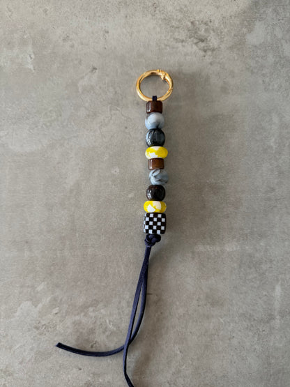 bag/key charm mixed - brown, greys, yellow and pattern.