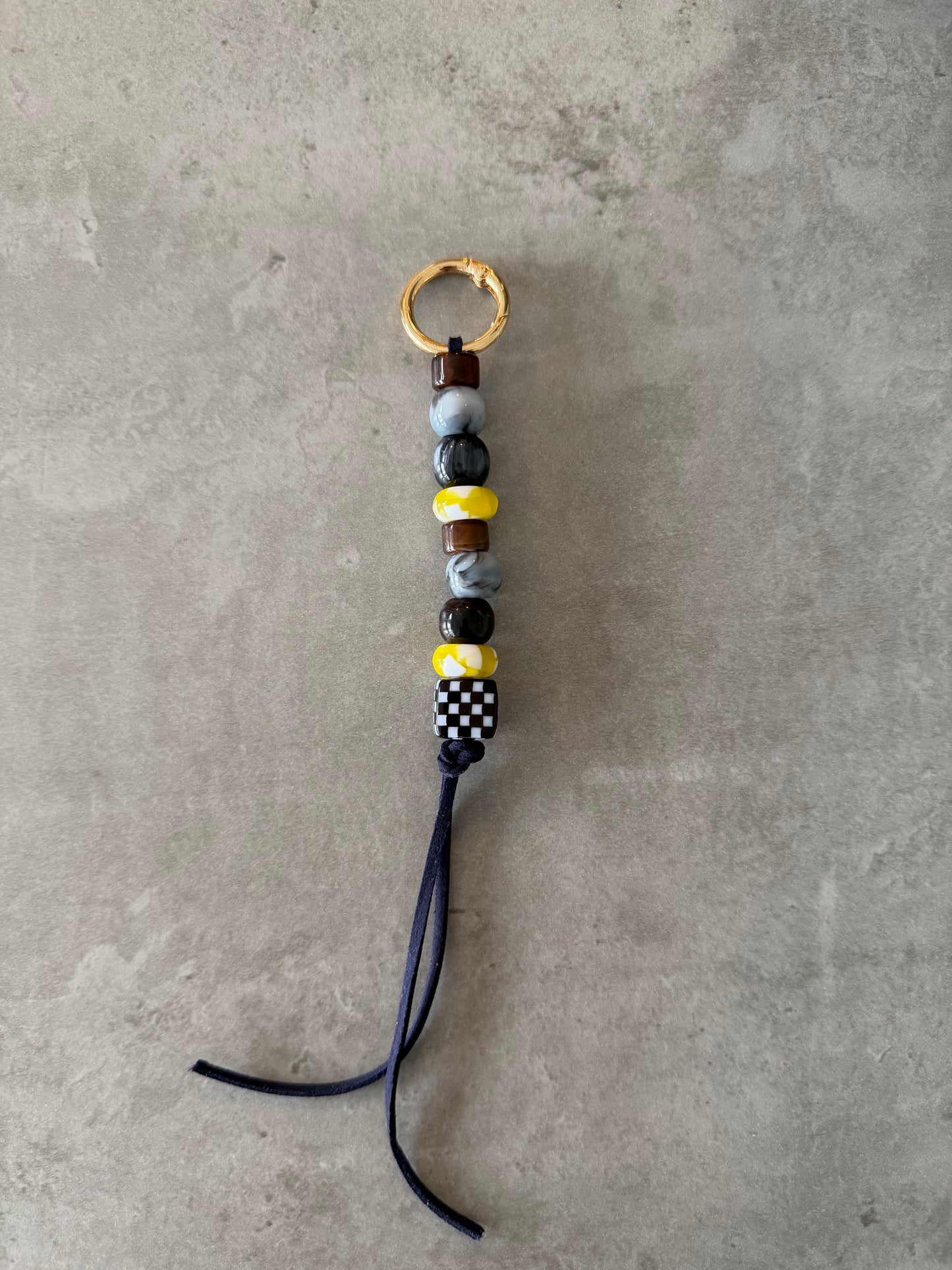 bag/key charm mixed - brown, greys, yellow and pattern.