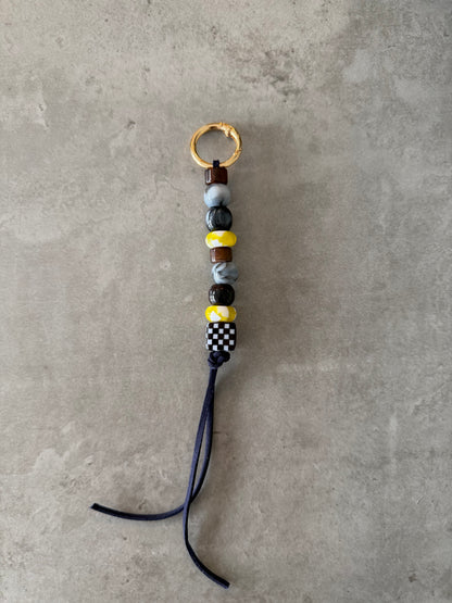 bag/key charm mixed - brown, greys, yellow and pattern.